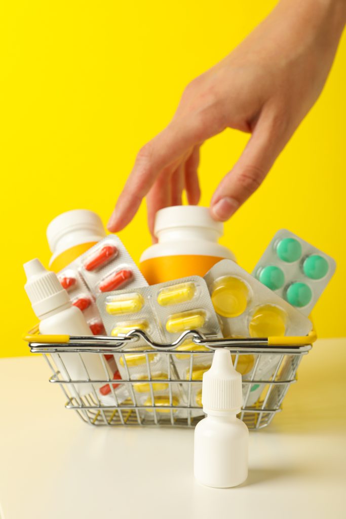 Metal basket with pills on a yellow background