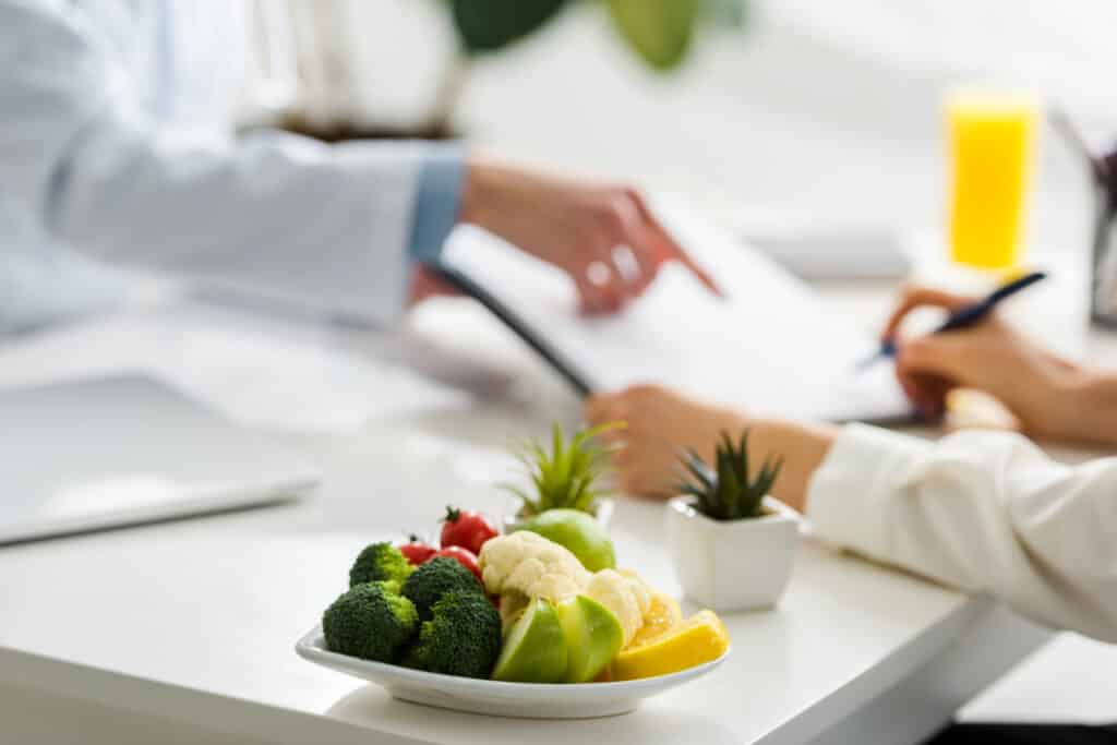 selective focus of tasty organic fruits and vegetables near women